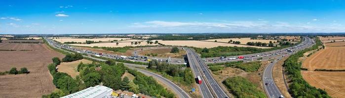 schöne luftaufnahme britischer verkehrsreicher autobahnen mit verkehr und stadt an einem sonnigen tag foto