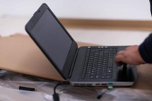 Mann mit Laptop, während er auf Karton liegt foto