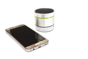 Handy und silberner Bluetooth-Lautsprecher isoliert auf weißem Hintergrund foto