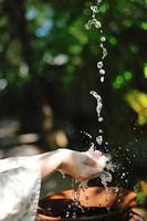 frisches Wasser auf die Hände der Frau spritzen foto