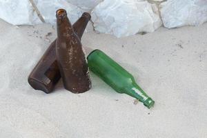 Verschwendung von zerbrochener Flasche auf Meeressandhintergrund foto