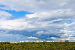 blauer bewölkter himmel über stadt und grüner stadtpark foto