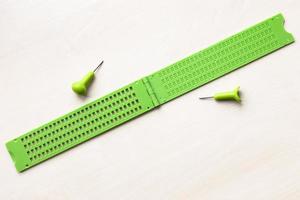 Offene Braille-Schreibtafel und Stift aus Kunststoff foto