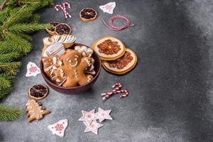 Lebkuchen, Christbaumschmuck, getrocknete Zitrusfrüchte auf grauem Betongrund foto