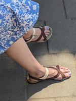 Frauenbeine in Sandalen. sommerliche Straßenmode. foto