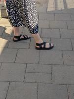 Frauenbeine in Sandalen. sommerliche Straßenmode. foto