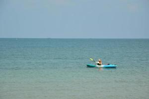 menschen auf einem blauen kanufahren auf dem meer. foto