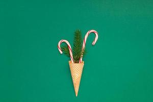 Weihnachtskarte mit Zuckerstangen in Waffelkegel foto