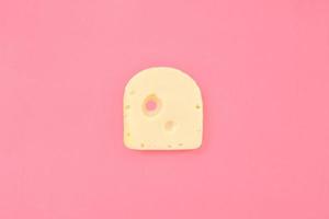 Stück Käse auf rosa Hintergrund foto