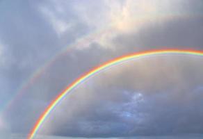 atemberaubende natürliche doppelte regenbögen plus überzählige bögen an einem see in norddeutschland foto