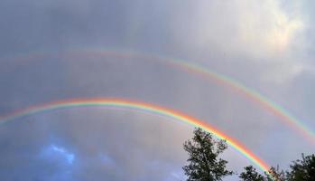 atemberaubende natürliche doppelte regenbögen plus überzählige bögen an einem see in norddeutschland foto