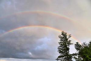 atemberaubende natürliche doppelte regenbögen plus überzählige bögen an einem see in norddeutschland foto