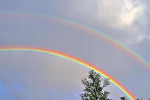 atemberaubende natürliche doppelte regenbögen plus überzählige bögen an einem see in norddeutschland foto