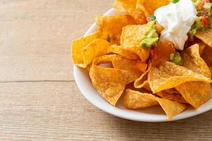 Nachos-Tortilla-Chips mit Jalapeno, Guacamole, Tomatensalsa und Dip foto