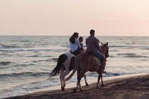 die familie verbringt zeit mit ihren kindern beim gemeinsamen reiten an einem wunderschönen sandstrand in sunet. foto