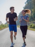 junges Paar Joggen entlang einer Landstraße foto