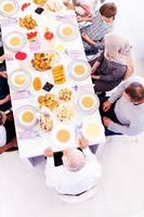 Draufsicht der modernen multiethnischen muslimischen Familie, die auf den Beginn des Iftar-Abendessens wartet foto