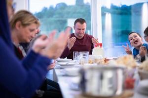 eid mubarak islamische familie, die vor halal iftar-abendessen betet foto