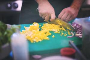 Kochhände schneiden frisches und leckeres Gemüse foto