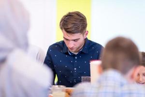 junger muslimischer mann, der iftar-abendessen mit der familie genießt foto