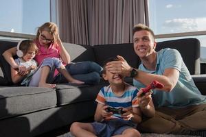 glückliche familie, die ein videospiel spielt foto