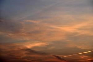 schönes Sonnenuntergangslicht und Wolken und eine Spur des Flugzeugs. Abendsonnenunterganglandschaft im Sommer. foto