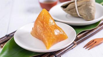 zongzi - basischer reisknödel - traditionelles süßes chinesisches kristallessen auf einem teller zum essen für drachenboot duanwu festivalfeierkonzept, nahaufnahme. foto