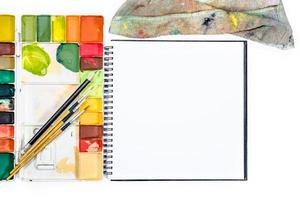 Nahaufnahme offenes Notizbuch mit Tablettfarben im Hintergrund foto