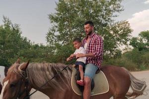 Vater und Sohn reiten gerne gemeinsam am Meer. selektiver Fokus foto