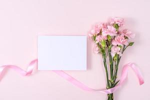 muttertag, valentinstag hintergrunddesignkonzept, schöner rosa nelkenblumenstrauß auf pastellrosa tisch, draufsicht, flache lage, kopierraum. foto
