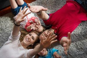 glückliche familie, die auf dem boden liegt foto