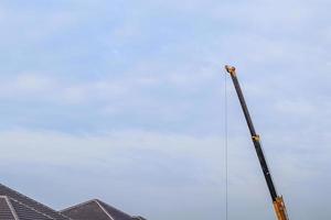 gelbe teleskoparme des mobilen baukranwagens auf der hausbaustelle foto