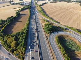 schöne luftaufnahme britischer verkehrsreicher autobahnen mit verkehr und stadt an einem sonnigen tag foto