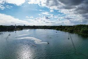 Kameraaufnahmen einer wunderschönen Luftdrohne von Willen Lake und Park, der sich in Milton Keynes, England, befindet. Die Menschen genießen an einem heißen sonnigen Sommertag am See foto