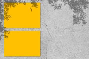 leeres gelbes quadratisches plakatmodell mit hellem schatten auf grauem betonwandhintergrund. foto