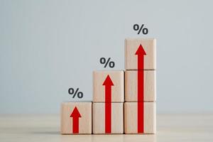 zinsfinanzierungs- und hypothekenzinskonzept. Holzklötze mit rotem Pfeil nach oben und Prozentzeichen, Finanzwachstum, Zinserhöhung, Inflation, Verkaufspreis und Steuererhöhungskonzept. foto