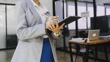 Finanzen des Geschäftsteams oder Buchhalter, die mit einem Taschenrechner arbeiten, um den zusammenfassenden Bericht der Geschäftsdaten, das Buchhaltungsdokument und den Laptop-Computer im Büro zu berechnen, Geschäftstreffenkonzept foto