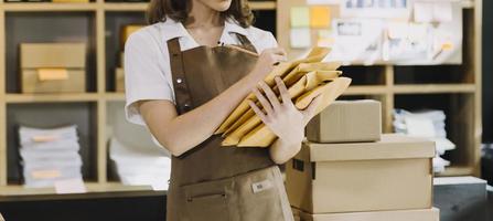 Porträt von KMU-Besitzern, die kleine Unternehmen gründen, zwei asiatische Frauen überprüfen Online-Bestellungen, die Produkte verkaufen, die mit Boxen arbeiten, freiberufliche Arbeit im Heimbüro, KMU-Unternehmen, Online-Kleinmittelunternehmen foto