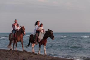 Die Familie verbringt Zeit mit ihren Kindern beim gemeinsamen Reiten an einem Sandstrand. selektiver Fokus foto