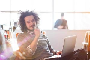 junger geschäftsmann, der computer bei der arbeit verwendet foto