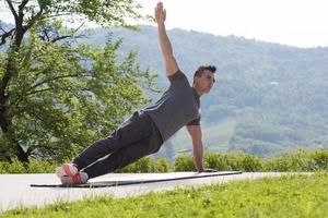 Mann, der morgendliche Yoga-Übungen macht foto