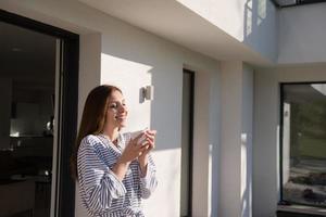 Frau im Bademantel genießt den Morgenkaffee foto