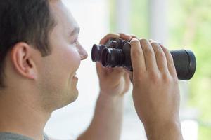 mann, der mit fernglas schaut foto