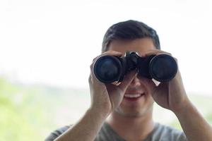 mann, der mit fernglas schaut foto