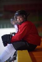 Kinder-Eishockeyspieler auf der Bank foto