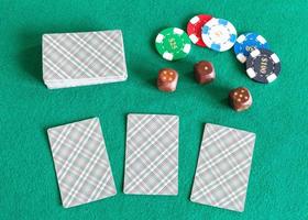 Kartendecks, Casino-Token und Würfel auf dem Tisch foto