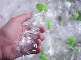 man hält plastikflaschen in der hand, recycelt und schützt die welt vor dem konzept der globalen erwärmung foto