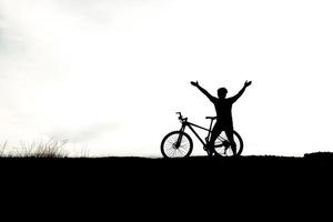 Silhouette einer Person, die Fahrrad fährt foto