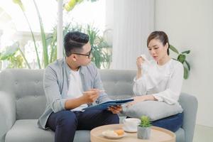 lächelnder junger asiatischer männlicher psychiater, der mit junger frau in seinem büro spricht. foto