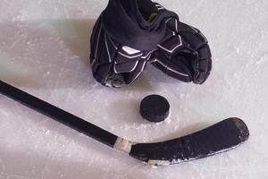Hockeyschläger und Puck auf Eis foto